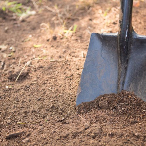 High angle view of shovel on dirt at community garden