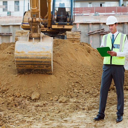 Mature man with clipboard on construction site